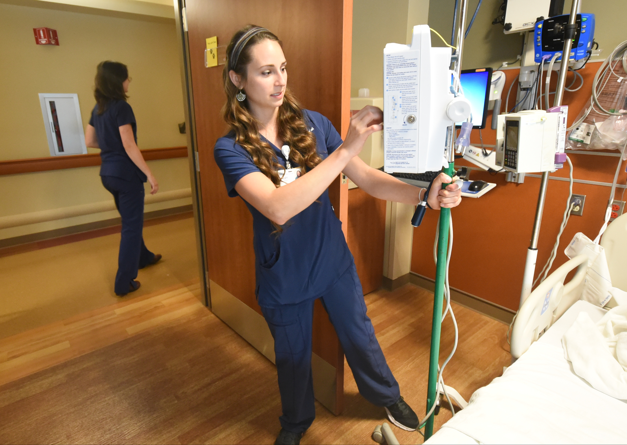 Haley McKinney, RNBSN at CHI Memorial, sets an IV pole in a patients room in the Guerry Heart and Vascular Center at CHI Memorial.