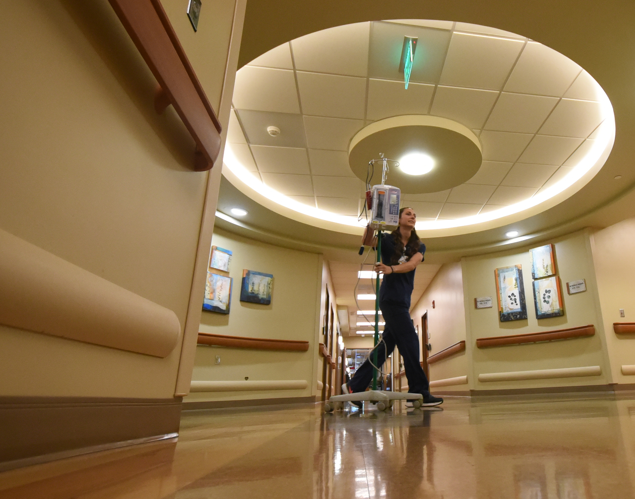 Haley McKinney, RNBSN at CHI Memorial, rolls an IV pole toward a patient room in the Guerry Heart and Vascular Center at CHI Memorial.