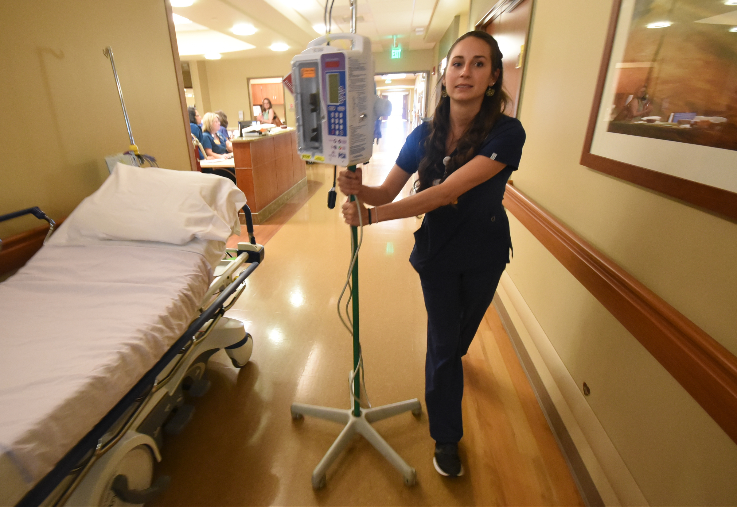 Haley McKinney, RNBSN at CHI Memorial, rolls an IV pole toward a patient room in the Guerry Heart and Vascular Center at CHI Memorial.