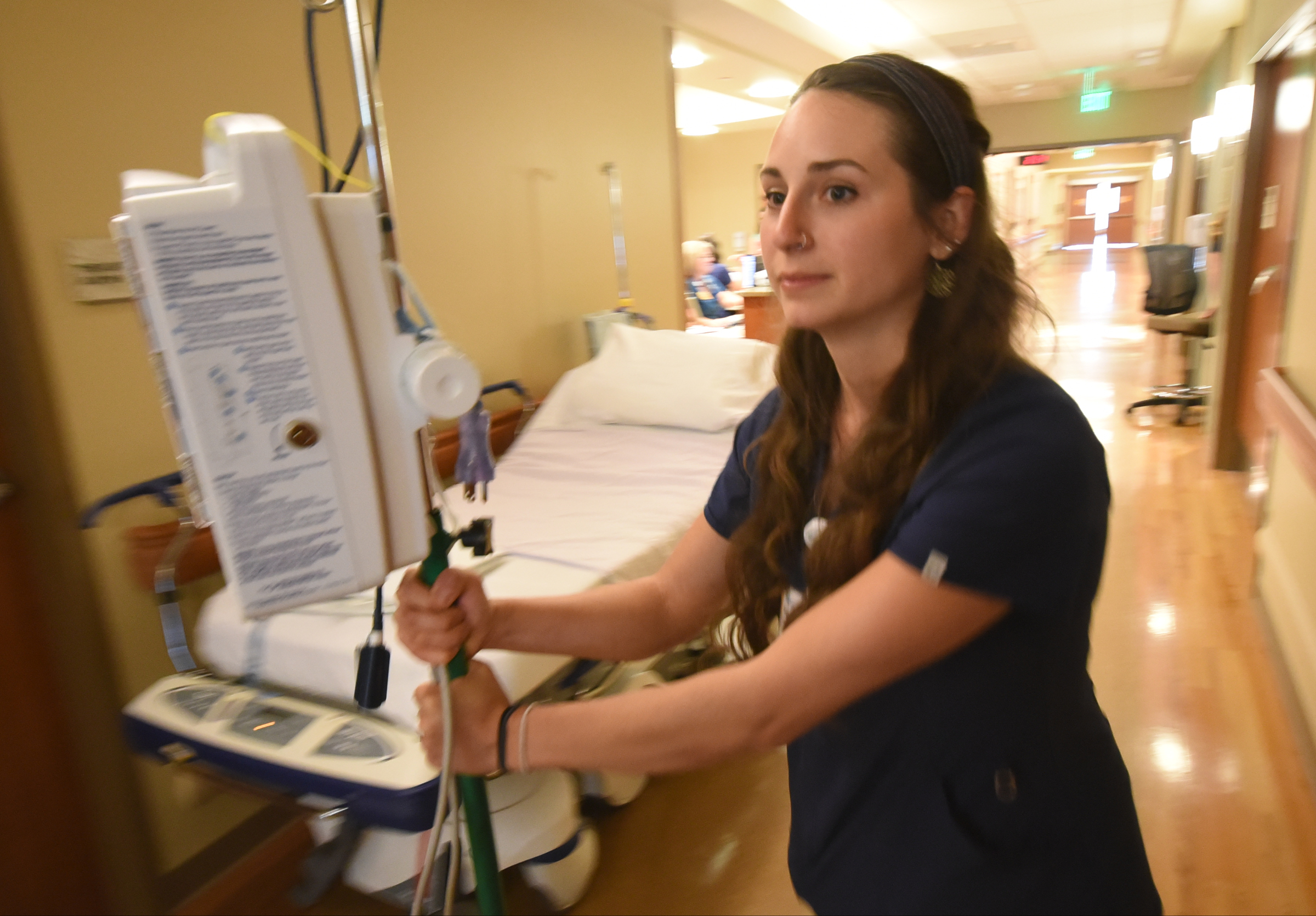 Haley McKinney, RNBSN at CHI Memorial, rolls an IV pole toward a patient room in the Guerry Heart and Vascular Center at CHI Memorial.