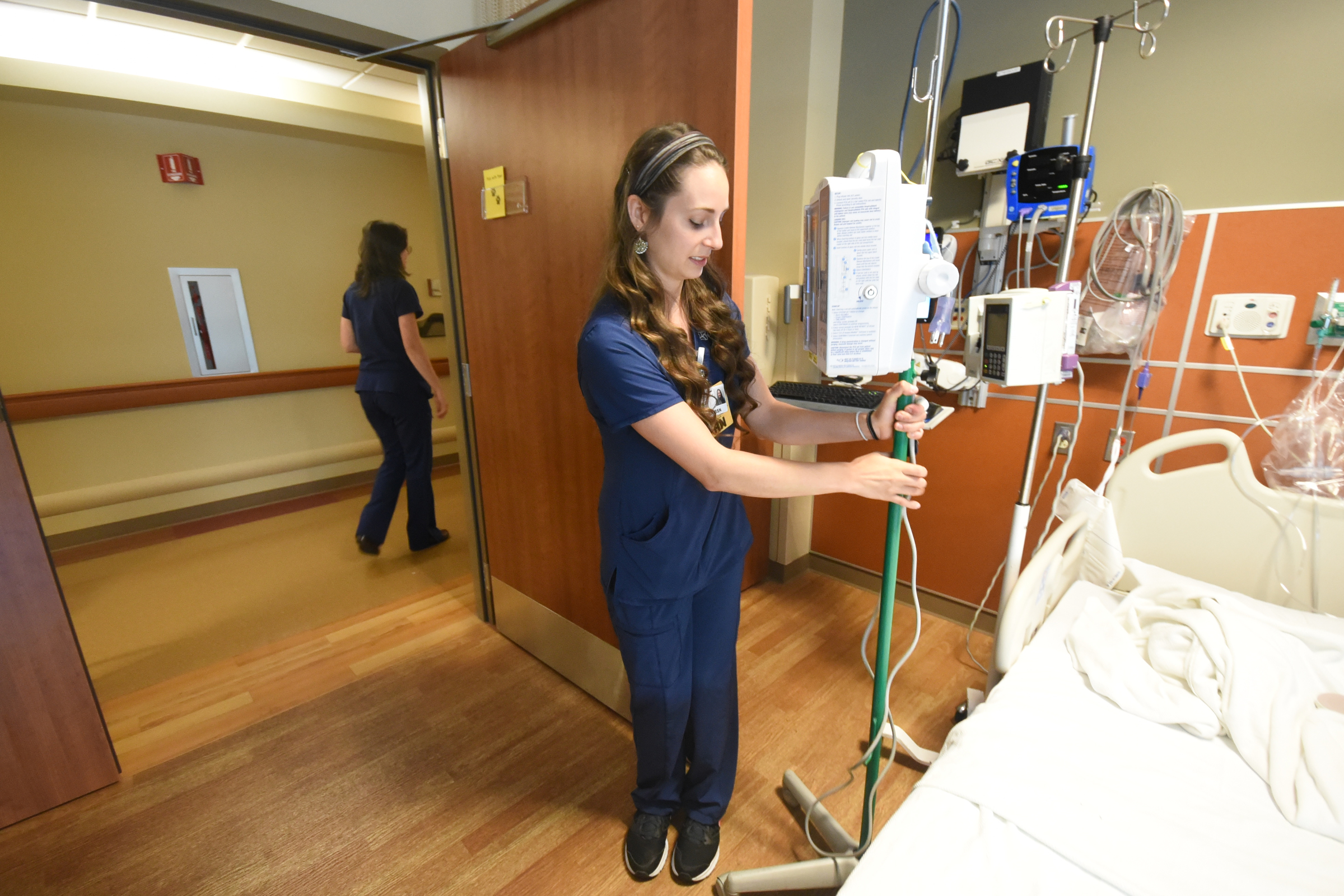 Haley McKinney, RNBSN at CHI Memorial, sets an IV pole in a patients room in the Guerry Heart and Vascular Center at CHI Memorial.
