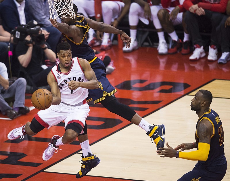 Toronto Raptors guard Kyle Lowry (7) drives around Cleveland Cavaliers center Tristan Thompson (13) as Cavaliers forward LeBron James (23) look on during first half Eastern Conference final playoff basketball action in Toronto on Monday, May 23, 2016.