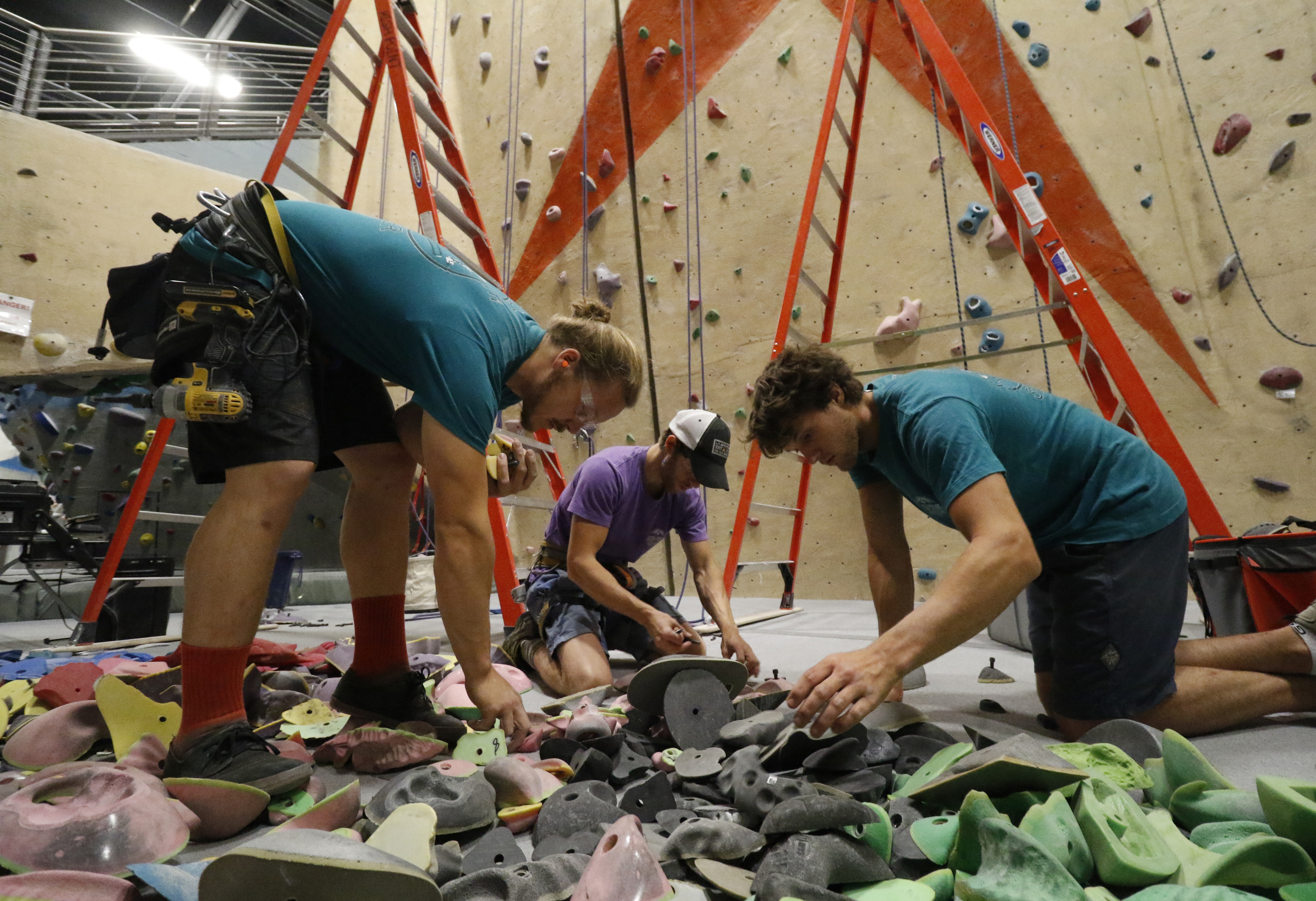 Staff Photo by Dan Henry / The Chattanooga Times Free Press- 5/19/16. Cody Grodzki, the director of route setting for High Point Climbing and Fitness, Andy Cutler and Johathan Gallagher from left, pick out holds while reseting the top rope room on May 19, 2016.