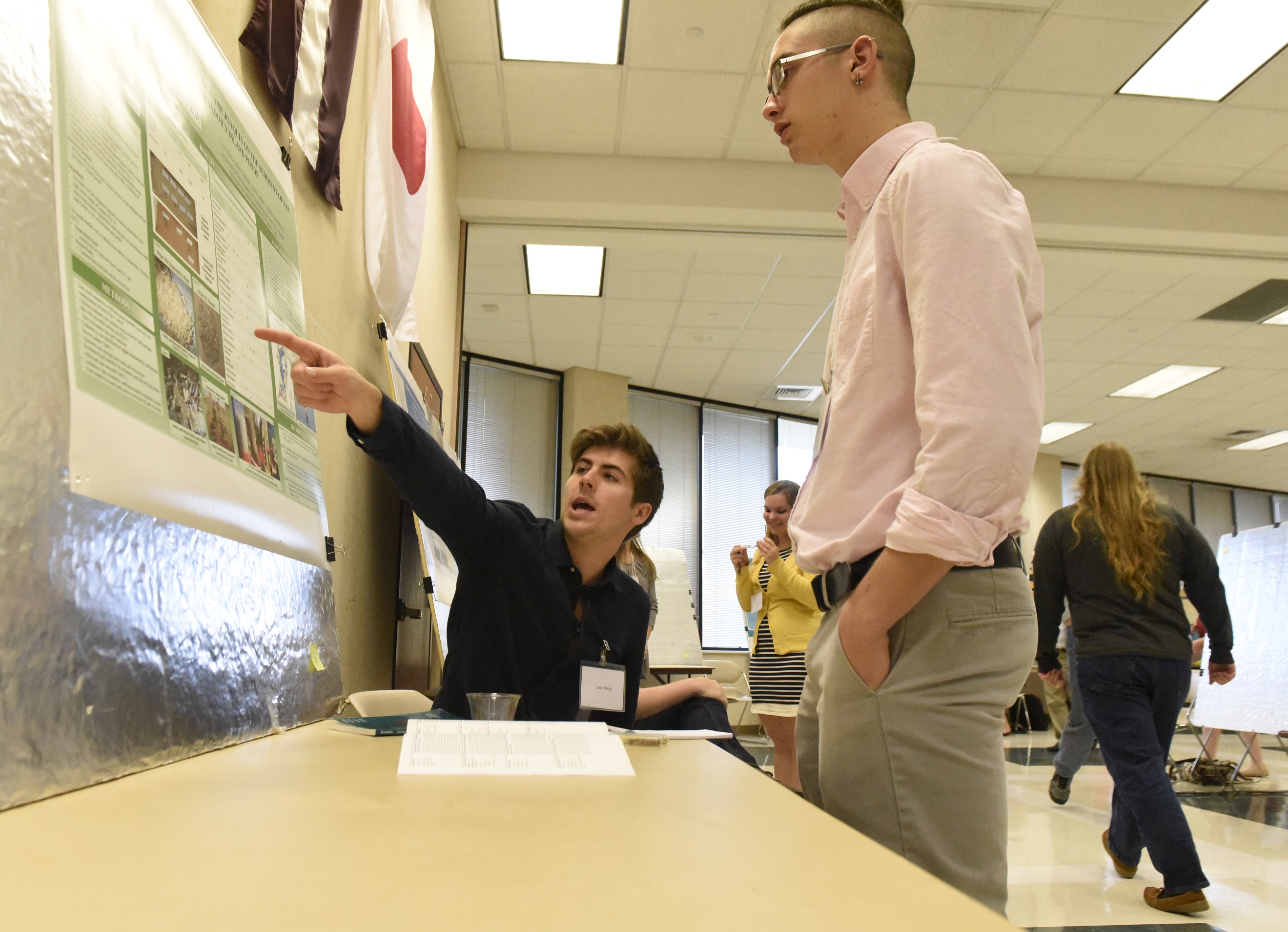 Luke Black, seated, one of several UTC students who travelled to the Bahamas to do biological and geological research, talks to student Patrick Zdunek (CQ) as the students present a display about their findings on Wednesday, Apr. 13, 2016, in Chattanooga, Tenn.