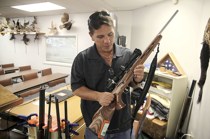 
              FILE - In this May 10, 2016, file photo, Jerry Ilo holds a gun that he uses to teach the Hawaii Department of Natural Resources hunter education training course in a classroom in Honolulu. Ilo was one of several Hawaii residents to speak out against a bill passed by lawmakers to allow Hawaii gun owners to be registered in a federal database that will automatically notify police if an island resident is arrested anywhere else in the country. (AP Photo/Marina Riker, File)
            