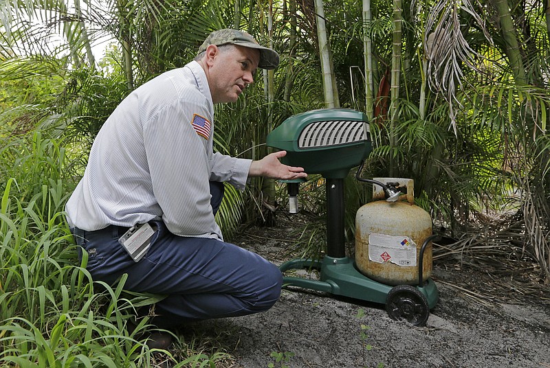 
              In this photo taken Thursday, May 12, 2016, Steve Noe, Martin County mosquito specialist, explains the use of the Mosquito Magnetic Pro, a machine used for luring and trapping mosquitoes, outside a home, in Rio, Fla. The dengue fever outbreak that infected 28 people in August and September of 2013 caught Florida's Atlantic coast by surprise. The mosquito-borne disease many associate with crowded, third-world conditions had spread among the pink plastic flamingoes in their modest suburban yards. (AP Photo/Alan Diaz)
            