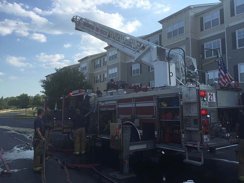 Firefighters work to extinguish a fast-moving brush fire late Tuesday that threatened the Amberleigh Ridge Apartments near Interstate 75 and East Brainerd Road.