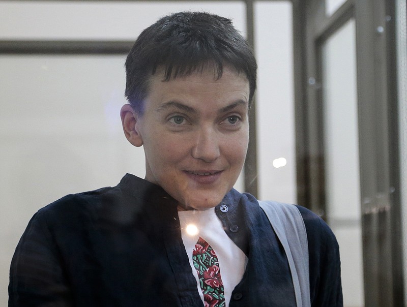 
              FILE - In this Monday, March 21, 2016 file photo, Ukrainian pilot Nadezhda Savchenko smiles to journalists from a glass-covered cage in court in Donetsk, Rostov-on-Don region, Russia. A lawyer for one of two Russian servicemen jailed in Ukraine says the groundwork is being laid for a possible exchange with Savchenko, who is imprisoned in Russia. Lawyer Valentin Rybin told the state news agency Tass on Wednesday, May 25, 2016, that both Russians have submitted a petition for a pardon to Ukrainian President Petro Poroshenko. (AP Photo/Ivan Sekretarev, File)
            