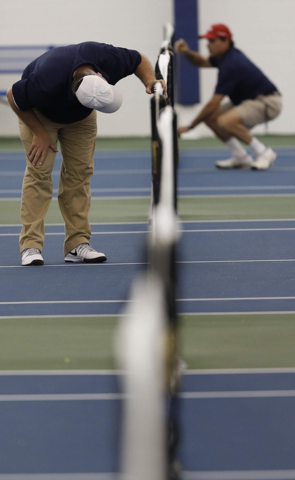 Staff Photo by Dan Henry / The Chattanooga Times Free Press- 5/25/16. TSSAA Umpire Dalen Farmer sets the indoor net heights as the competition moves indoors after rain began to fall early Wednesday morning during the TSSAA Division II Class AA Girls' State Tennis Championships in Murfreesboro, TN., on May 25, 2016.