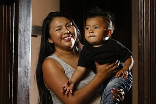 Red Bank High School valedictorian Leslie Tomas plays with her year-old son, Iker Perez, at their home.