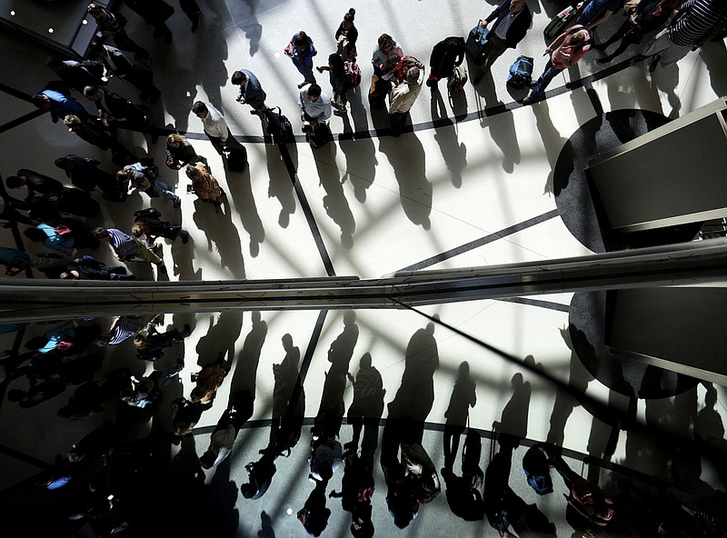 FILE - In this March 10, 2016, file photo, passengers are reflected in glass as they line up to go through a security checkpoint under the atrium of the domestic passenger terminal at Hartsfield-Jackson Atlanta International Airport in Atlanta. Airport security lines have become so bad that airlines themselves are urging passengers to share their frustration with the government on social media. Airlines for America, the industry's trade group, just launched a website called iHateTheWait.com, encouraging fliers to post photos of the lines on Twitter and Instagram along with the hashtag #iHateTheWait. (AP Photo/David Goldman, File)