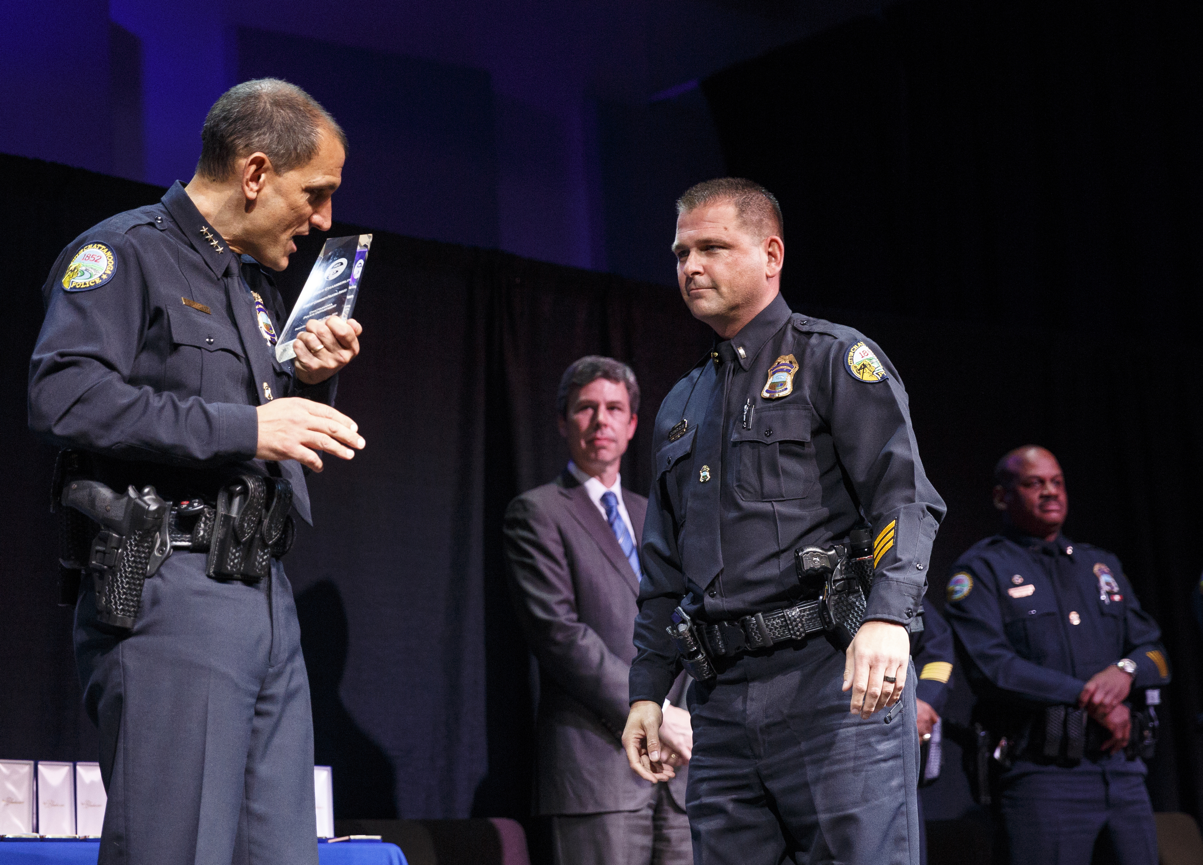 Chief Fred Fletcher, left, shines the Spirit of Community Policing award before presenting it to Lt. Eddy Chamberlin at the Chattanooga Police Department's annual awards ceremony held at Calvary Chapel on Thursday, May 26, 2016, in Chattanooga, Tenn. In addition to normal awards, officers were awarded for their response to last year's July 16 shootings at two military facilities in Chattanooga.