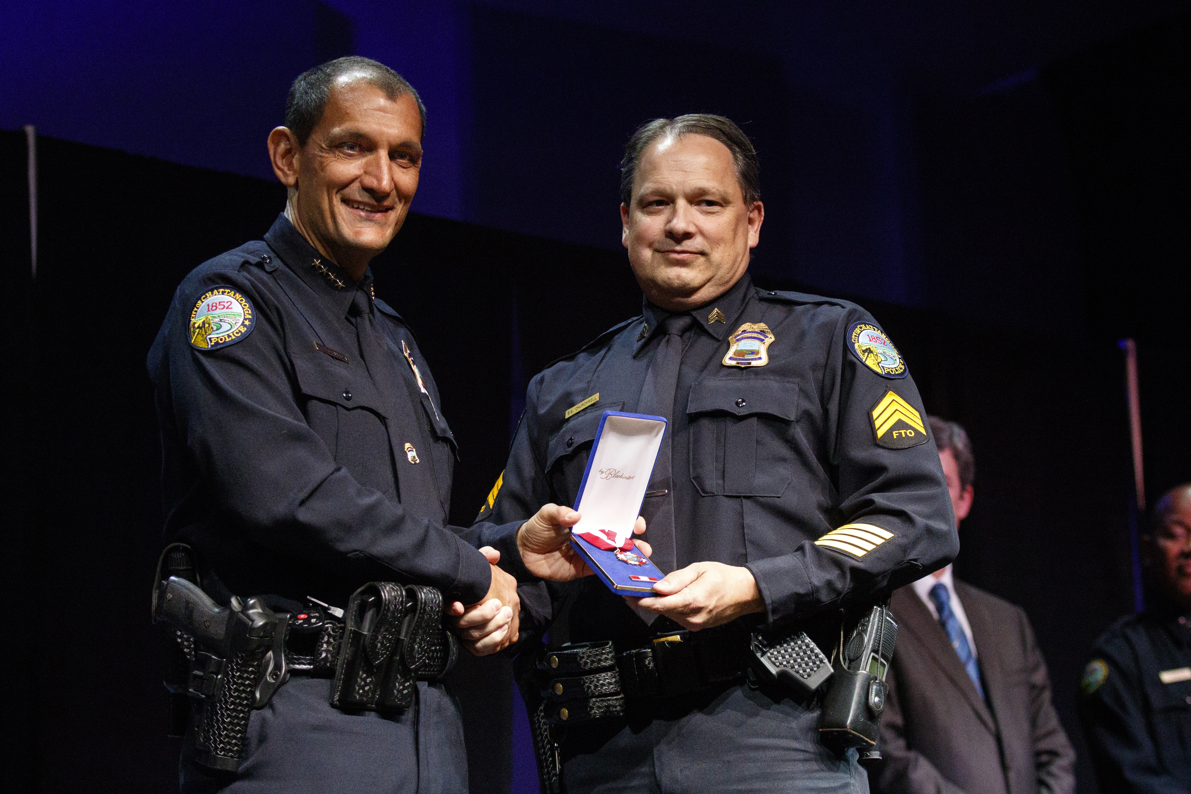 Chief Fred Fletcher, left, awards Sgt. Brian Churchwell a life saving award during the Chattanooga Police Department's annual awards ceremony held at Calvary Chapel on Thursday, May 26, 2016, in Chattanooga, Tenn. Sgt. Churchwell was presented the award for pulling an endangered child away from Javario Eagle before Eagle was shot and killed by police last year.