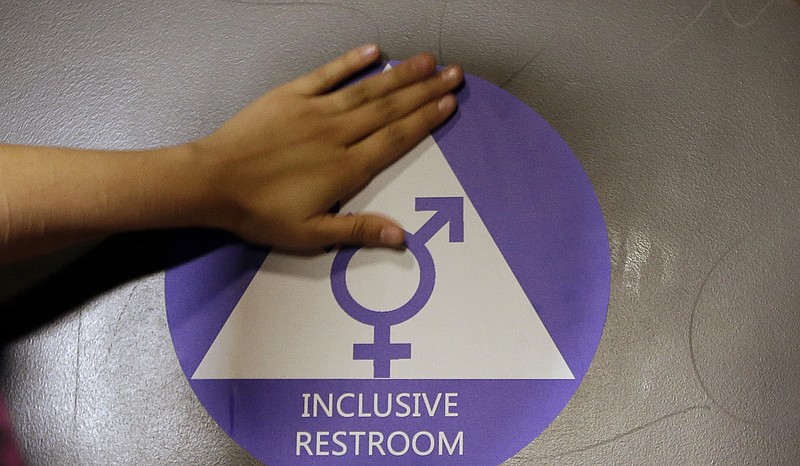 
              FILE - In this May 17, 2016 file photo, a new sticker is placed on the door at the ceremonial opening of a gender neutral bathroom at Nathan Hale High School in Seattle. Conservatives angered by the inclusion of LGBT protections in an otherwise routine spending bill scuttled the measure Thursday, May 26, 2016, a stark display of the potency of a civil rights issue suddenly prominent in the presidential race and responsible for a legal standoff between the Obama administration and several states. (AP Photo/Elaine Thompson, File)
            