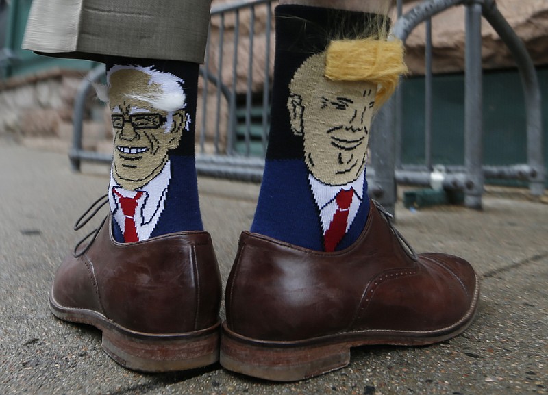 
              Colorado Gov. John Hickenlooper shows off his socks--one with Democratic presidential candidate Bernie Sanders and the other with Republican candidate Donald Trump--before entering his former brewpub for a book signing event to mark the release of his autobiography Thursday, May 26, 2016, in Denver. Hickenlooper, who is term-limited, is doing book talk rounds this week, reviving speculation that he is positioning himself to join Hillary Clinton's presidential campaign ticket. (AP Photo/David Zalubowski)
            