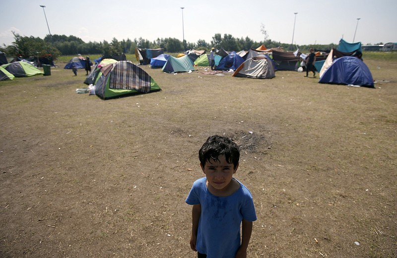 
              A boy stands in the makeshift refugee camp near the Horgos border crossing into Hungary, near Horgos, Serbia, Friday, May 27, 2016. Nearly 400,000 refugees passed through Hungary last year on their way to richer EU destinations. The flow was slowed greatly by Hungary's construction of razor-wire fences on its borders with Serbia and Croatia. (AP Photo/Darko Vojinovic)
            