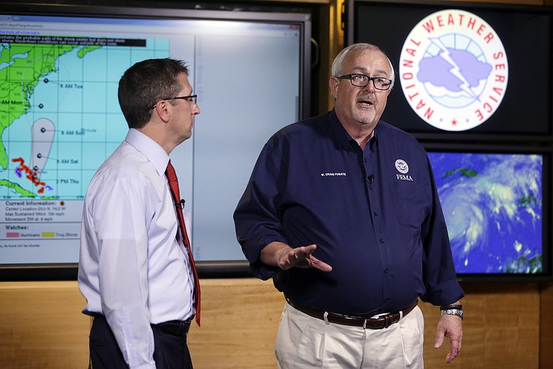 
              FILE- In this Oct.1, 2015 file photo, Craig Fugate, Administrator of the Federal Emergency Management Agency (FEMA), right, talks about the status of Hurricane Joaquin as it moves through the eastern Bahamas as Rick Knabb, Director of the National Hurricane Center, left, participate in a media briefing at the National Hurricane Center. The U.S. government is set to release its forecast for how many hurricanes and tropical storms are expected to form over Atlantic and Caribbean waters in the next six months. It’s an annual reminder from the National Oceanic and Atmospheric Administration that coastal living comes with significant risks. (AP Photo/Lynne Sladky, File)
            