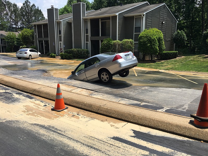 A water main break led to a car getting stuck in a sinkhole Friday at Mountain Brook Apartments at the foot of Signal Mountain.