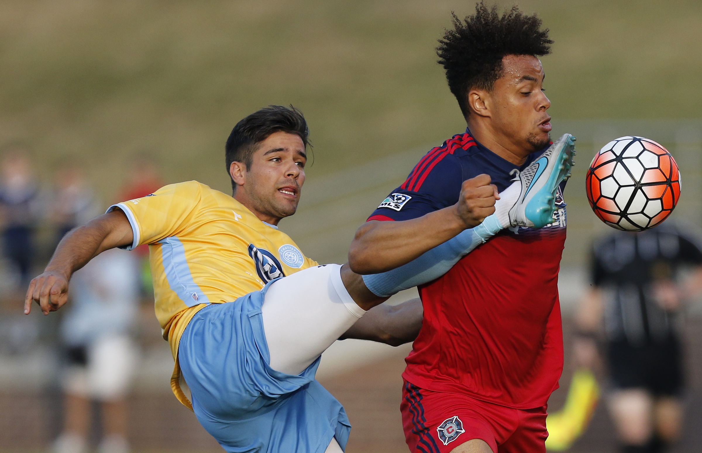CFC's Samuel Goni kicks high on Chicago's Abdou Samake during Chattanooga FC's Hank Steinbrecher Cup championship match against the Chicago Fire at Finley Stadium on Saturday, May 28, 2016, in Chattanooga, Tenn.