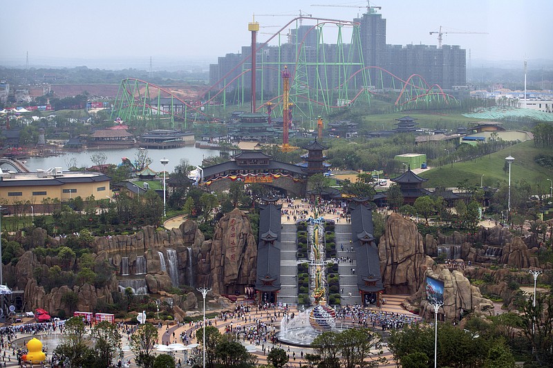 
              Visitors make their way toward the Nanchang Wanda Park theme park during its grand opening day in Nanchang in southeastern China's Jiangxi province, Saturday, May 28, 2016. China's largest private property developer, the Wanda Group, opened an entertainment complex on Saturday that it's positioning as a distinctly homegrown rival to Disney and its $5.5 billion Shanghai theme park opening next month. (AP Photo/Mark Schiefelbein)
            