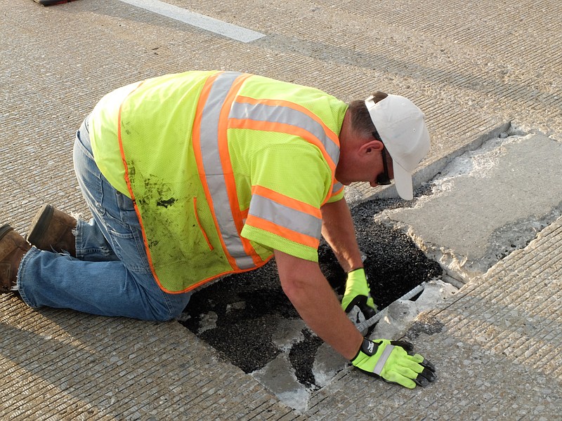 TDOT Maintenance employee Bob Jewusiak checks the condition of the concrete late Sunday where a hole in the bridge has formed in the eastbound right lane of Interstate 24, at the 178/6 mile-marker.