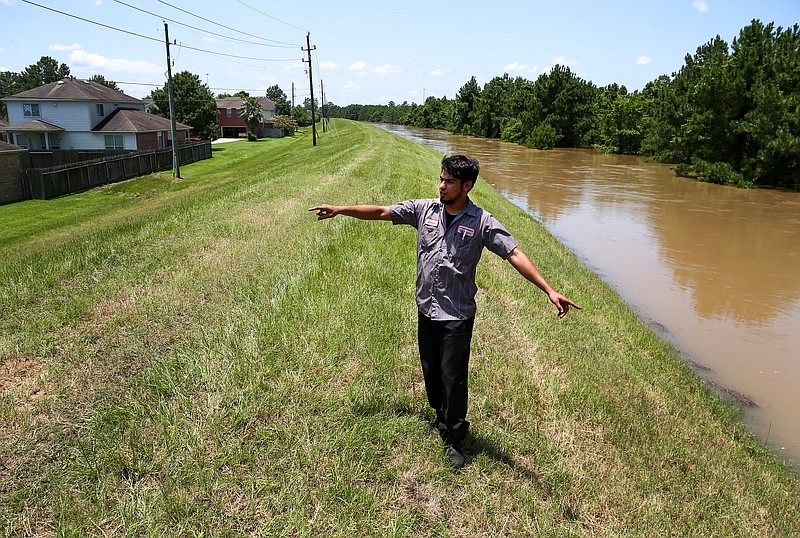 
              Leo Hernandez talks about the water level in Spring Creek, in the Northwood Pines subdivision, Saturday, May 28, 2016, in Spring, Texas. The water level in the creek rose after this week's torrential rains and is expected to crest sometime in the evening.  (Jon Shapley/Houston Chronicle via AP) MANDATORY CREDIT
            