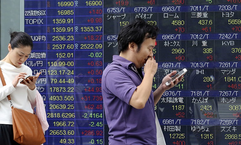 
              People look at their cell phone in front of an electronic stock board of a securities firm in Tokyo, Monday, May 30, 2016. Asian stocks rose Monday following Wall Street's gains as investors looked ahead to economic data this week from China, Australia and Korea. (AP Photo/Koji Sasahara)
            