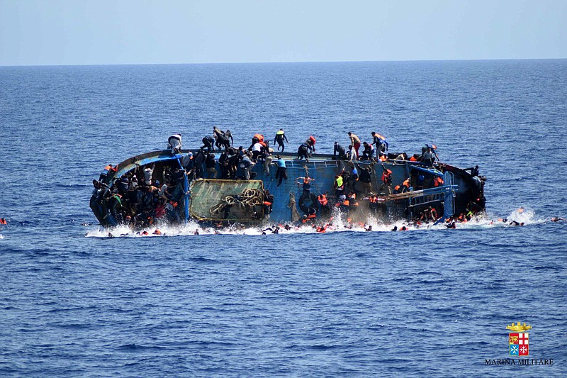
              FILE - In this May 25, 2016 file photo made available by the Italian Navy, people try to jump in the water right before their boat overturns off the Libyan coast. Over 700 migrants are feared dead in three Mediterranean Sea shipwrecks south of Italy in the last few days as they tried desperately to reach Europe in unseaworthy smuggling boats, the U.N. refugee agency said Sunday, May 29, 2016. (Italian navy via AP Photo, file)
            