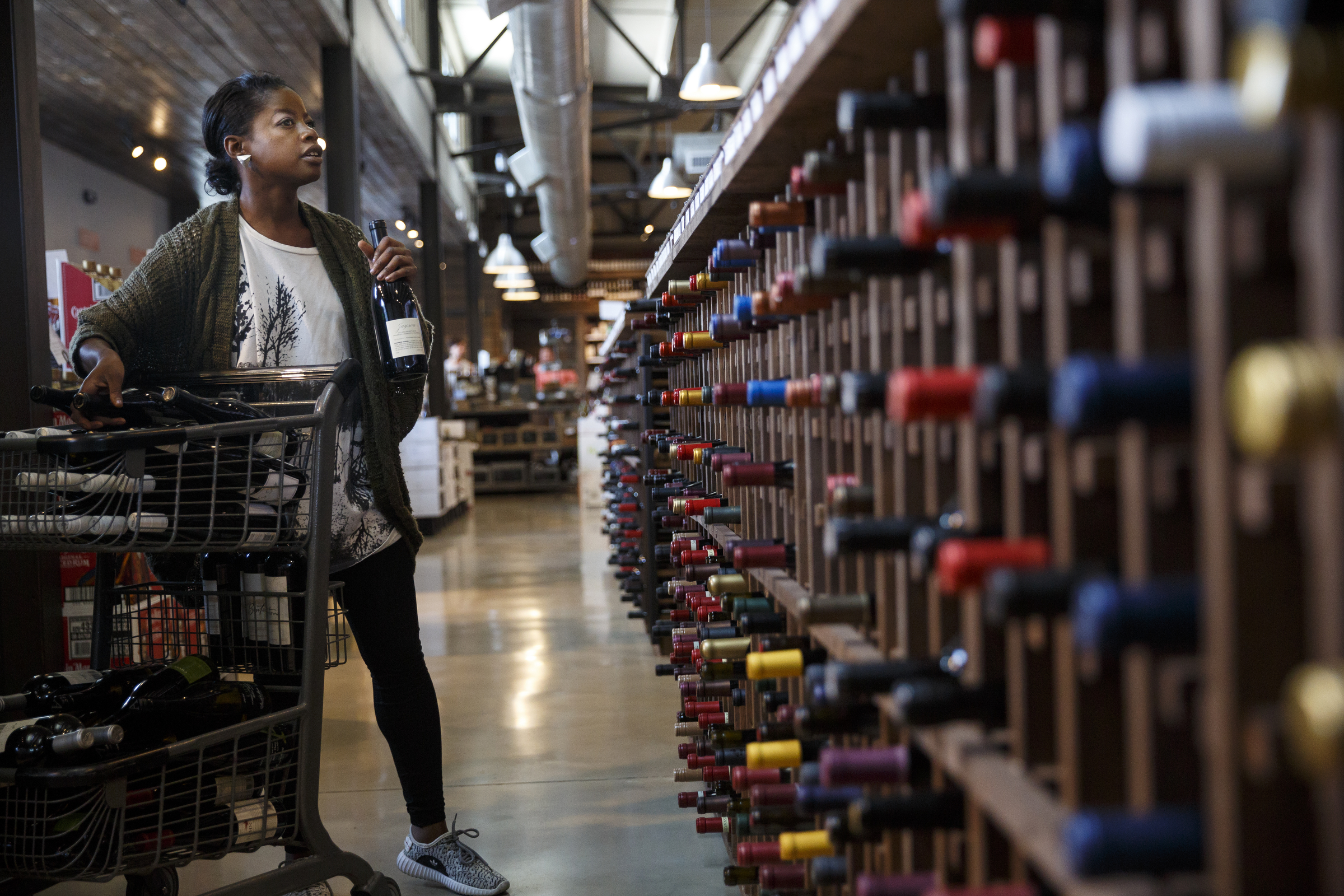 Joi Mason stocks wine racks with new bottles at Imbibe Chattanooga, a wine-focused liquor store, on Wednesday, May 25, 2016, in Chattanooga, Tenn. Beginning July 1, Tennessee grocery stores will be allowed to sell wine, but they will not be able to buy in bulk the way liquor stores can.