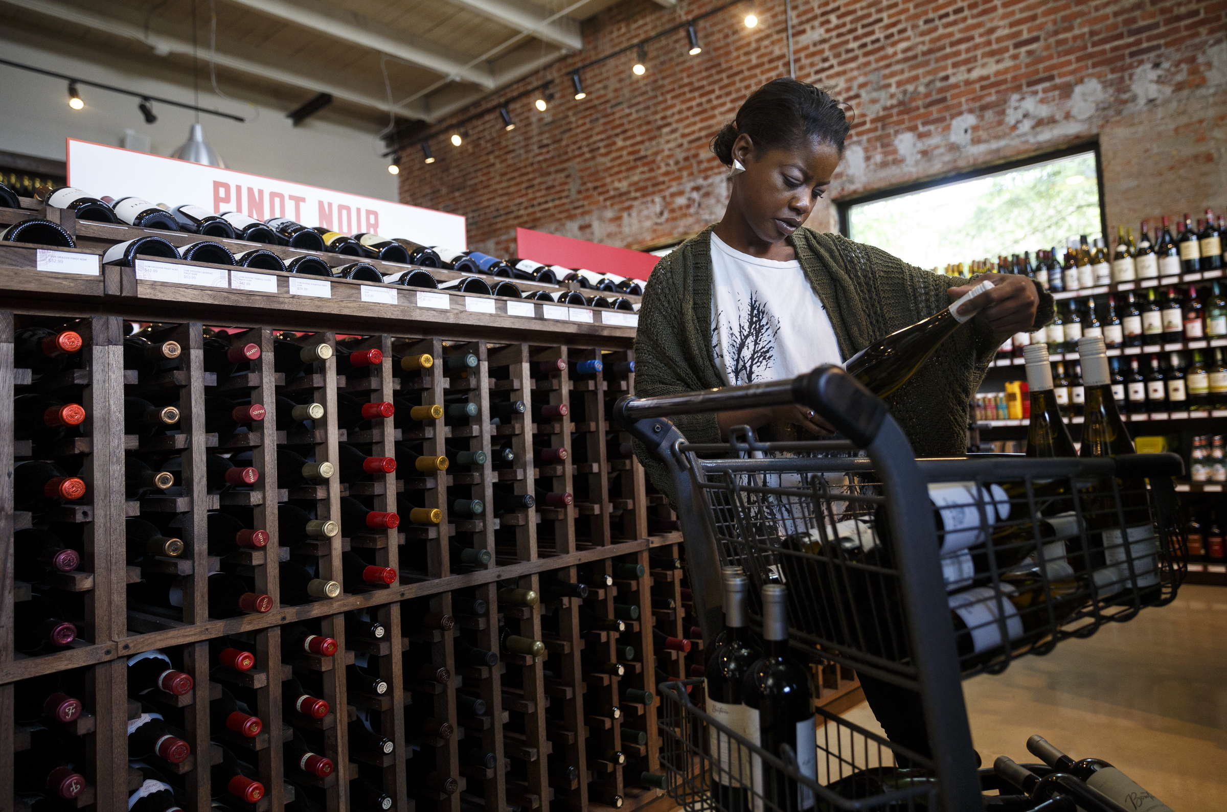Joi Mason stocks wine racks with new bottles at Imbibe Chattanooga, a wine-focused liquor store, on Wednesday, May 25, 2016, in Chattanooga, Tenn. Beginning July 1, Tennessee grocery stores will be allowed to sell wine, but they will not be able to buy in bulk the way liquor stores can.