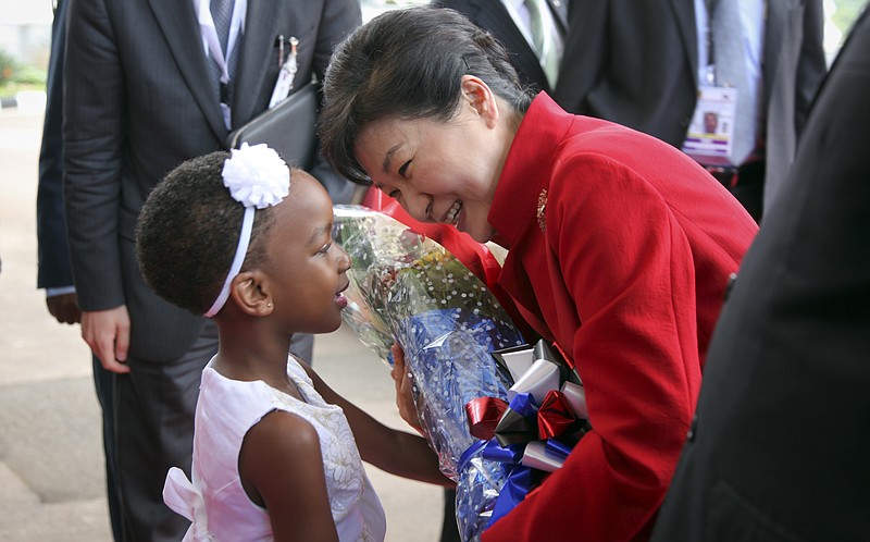 
              South Korea's president Park Geun-hye receives flowers from Megan Makanga, a grade one pupil of Charm International School, as she arrives at State House in Entebbe, Uganda, Sunday, May 29, 2016. Uganda and South Korea have signed cooperation agreements that officials hope will lead to transfer of technology as Uganda tries to implement an ambitious industrialization program. (AP Photo/Stephen Wandera)
            