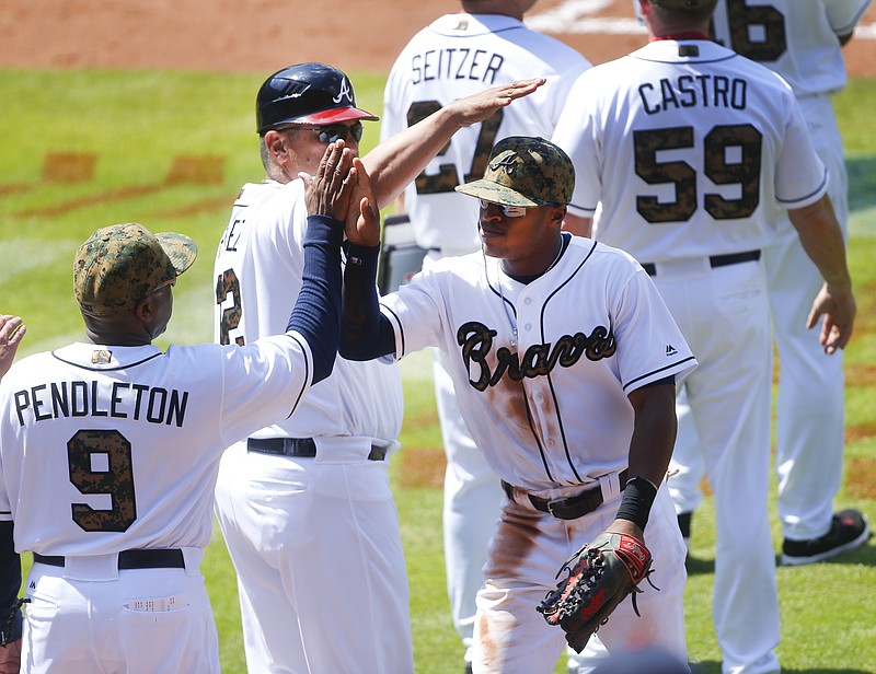 Atlanta Braves center fielder Mallex Smith (17), right, celebrates with bench coach Terry Pendleton (9) and first base coach Eddie Perez (12) after defeating the San Francisco Giants 5-3 in a baseball game Monday, May 30, 2016, in Atlanta. (AP Photo/John Bazemore)