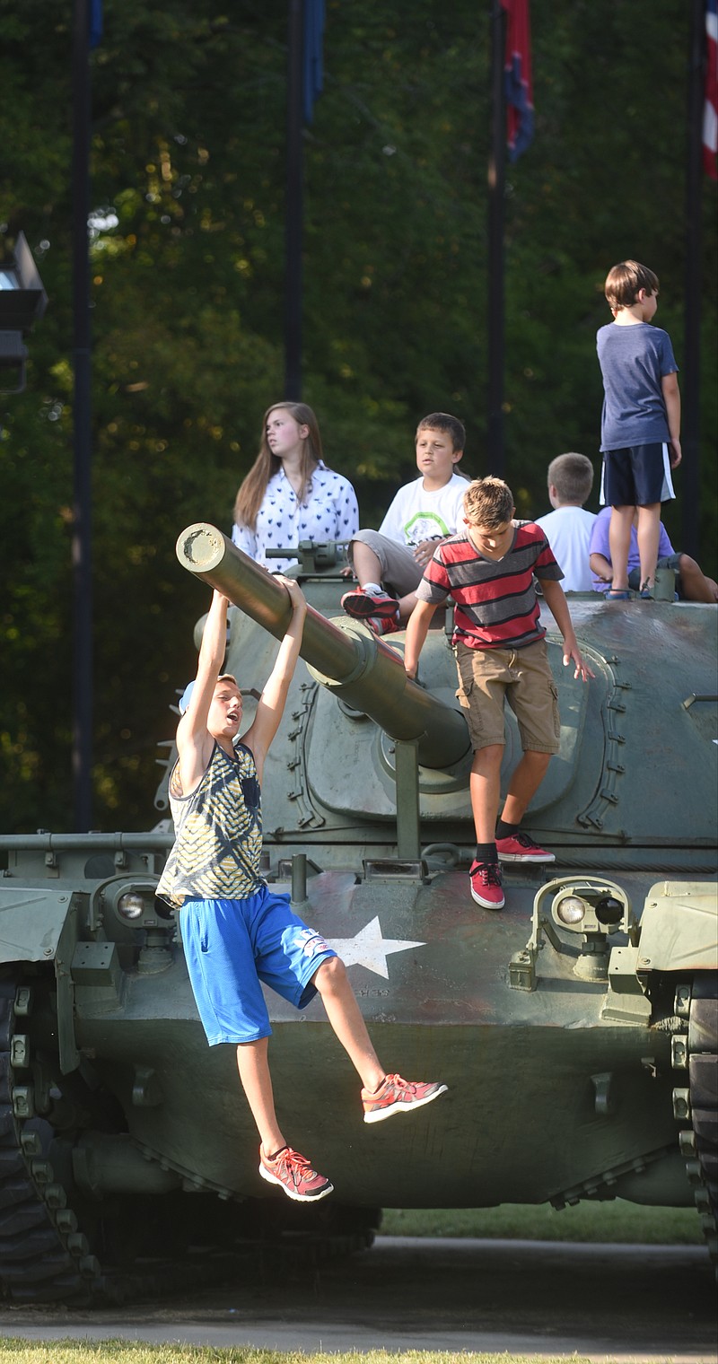 Alex Klischies hangs from a tank Monday, September 7, 2015 at the Labor Day celebration in Collegedale Veterans Memorial Park.