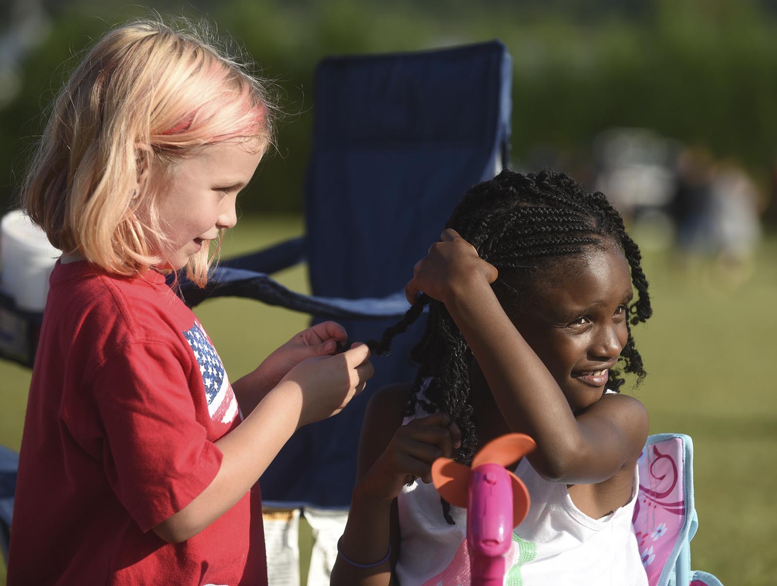 Makayla Howard, left, plays with Telia Fisher's hair Monday, September 7, 2015 at the Labor Day celebration in Collegedale Veterans Memorial Park.