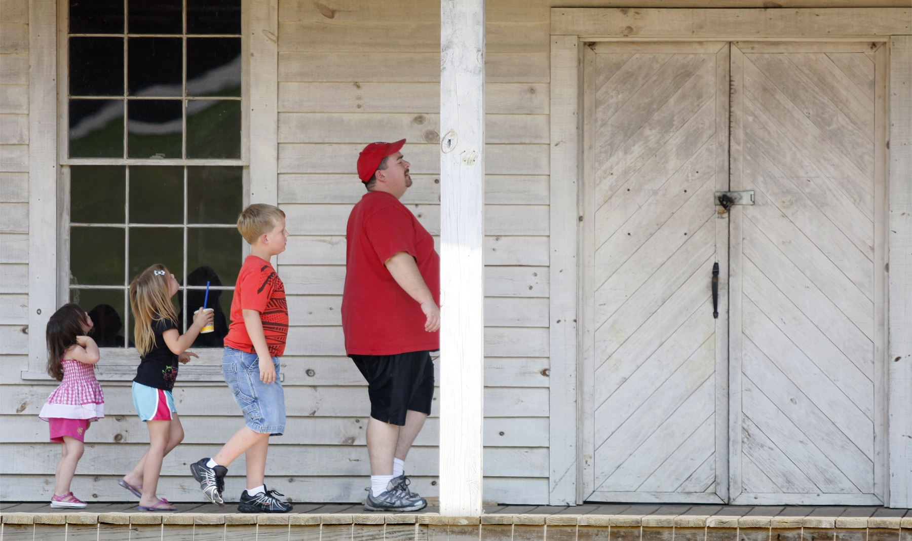 Staff Photo by Allison Carter/Chattanooga Times Free Press - Jun 12, 2011 - Ellie Holloway (cq), Emma Holloway (cq), Keegan Holloway (cq), and Kelly Holloway (cq) walk across Lee and Gordon's Mills' front porch Sunday in Chickamauga, Ga. They were driving around and decided to finally stop by the mill after driving past it various times throughout the past.