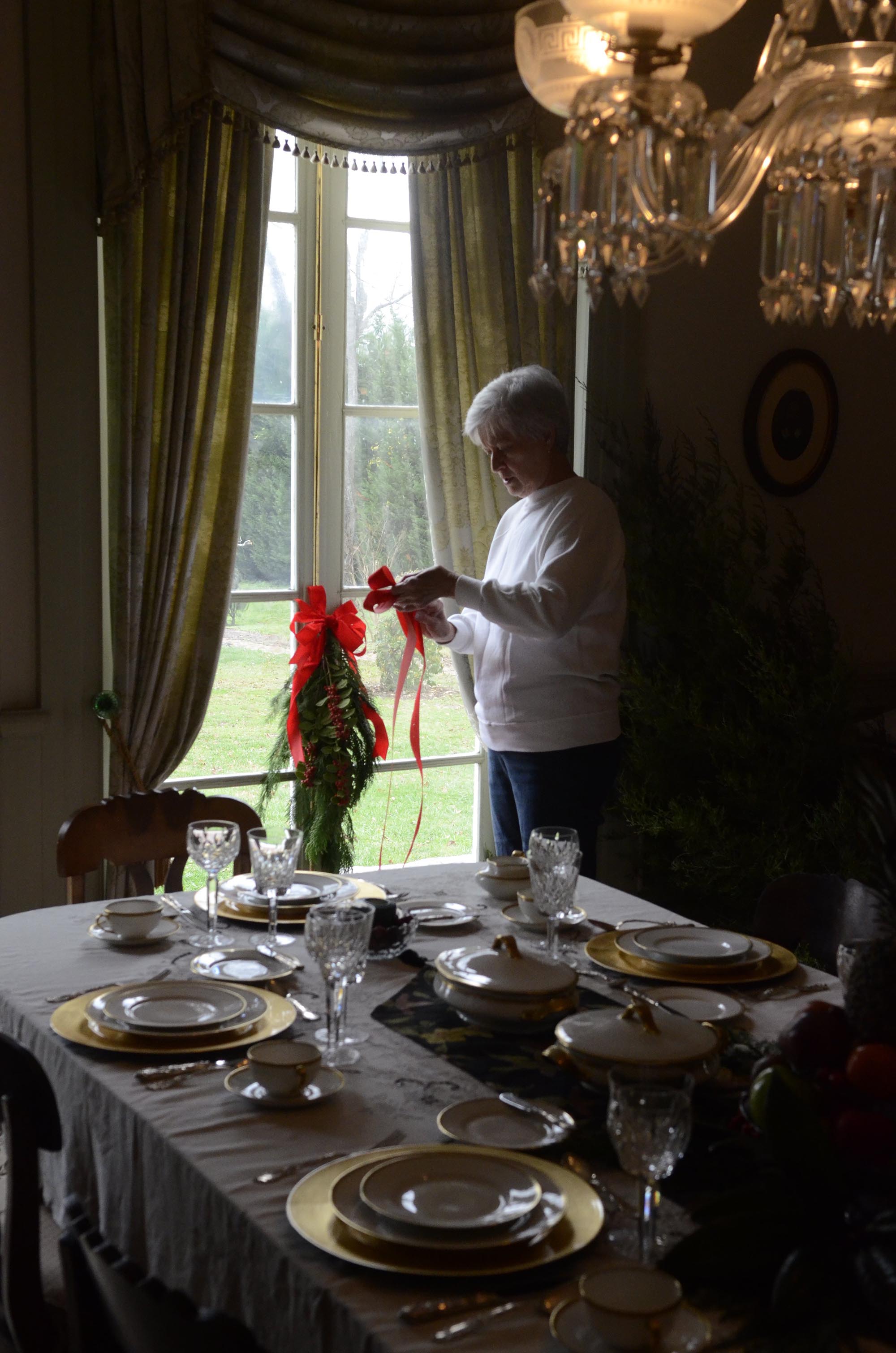 Linda Love (CQ) of the newly-formed Friends of the Gordon Lee Mansion installs natural and handmade Christmas decorations at the historic Chickamauga home Wednesday for the upcoming candlelight tour, which will be held on Friday and Saturday nights from 6-9 p.m. during the next two weekends. An admission price of four dollars (two dollars for children 12 and under) includes homemade cookies and cider, and proceeds will benefit their organization as well as providing camp scholarships for the First Baptist Church of Chickamauga.