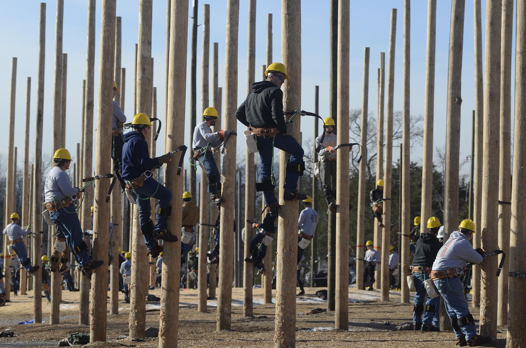 Linemen-in-training climb utility poles Thursday at the Southeast Lineman Training Center south of Trenton. A crew from Super Chief, a Chattanooga video production company, records the actions of a class for "Woodwalkers," a reality TV show.