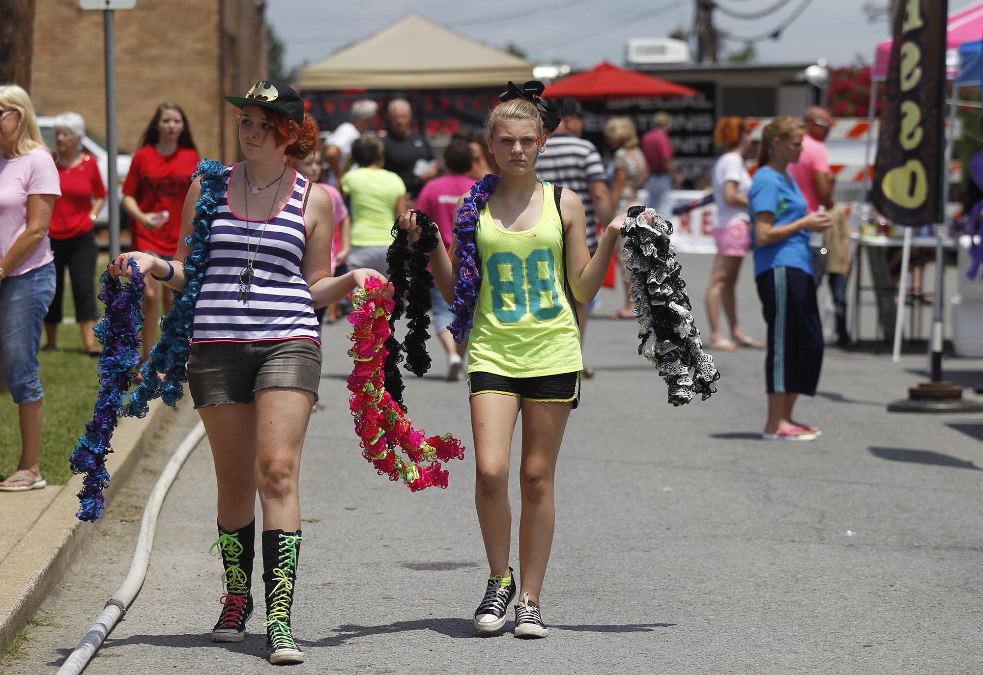 Tristen Butler, left, and Katie Green sell boas Saturday, Aug. 2, 2014, at the Dade County Days Festival at Veterans Memorial Park in Trenton, Ga. The festival included a day of musical performances, vendors, inflatables, and a rubber duck race.