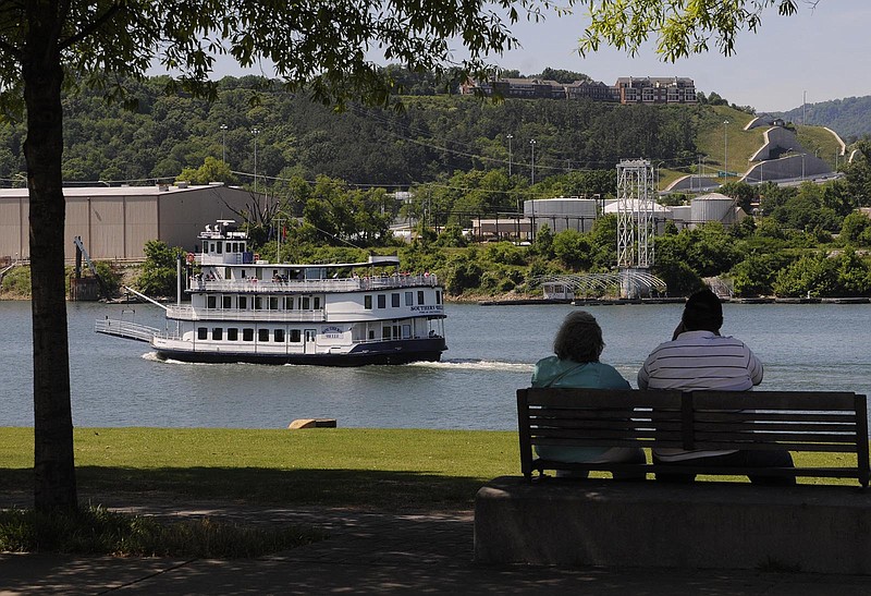Robert and Susan Juengel, of Fayetteville, Tenn., sit in the cool shade at Ross's Landing as the Southern Belle riverboat passes with patrons atop the lookout deck Wednesday. "We're just enjoying the riverfront because it's a nice place to sit," Juengel said. "It's fun to watch the boats."
