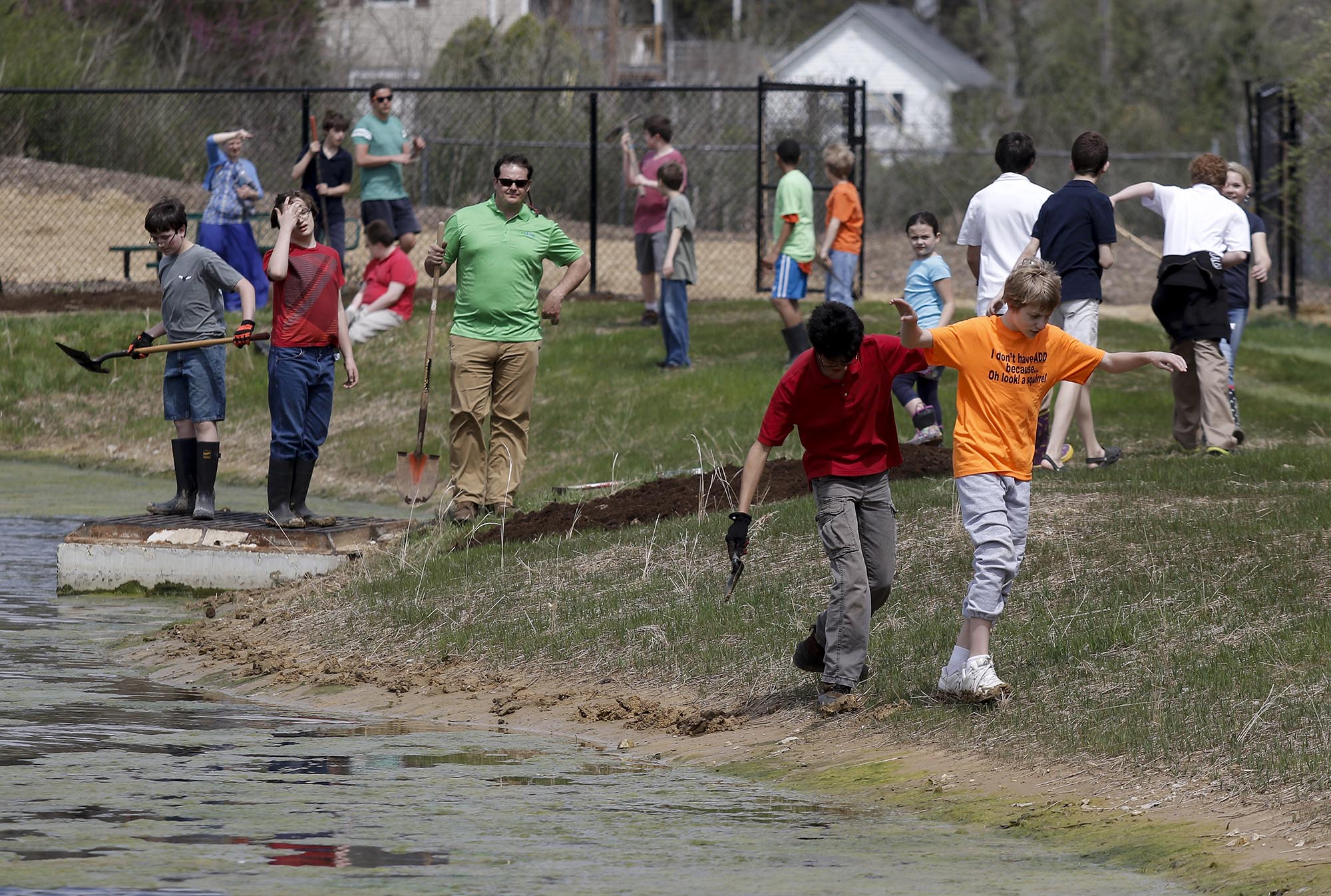 Students walk around a wetlands-type stormwater filtration and drainage system behind the Four Squares Business Center on Thursday, March 26, 2015, in Chattanooga, Tenn. Students from Scenic Land School planted native bushes and plants around the wetlands pond to attract butterflies, particularly endangered monarchs, and improve the quality of the water. The system was completed late last year as a greener alternative to a traditional parking lot stormwater drain, and the variety of plants in and outside of the pond helps to filter stormwater that collects and provides habitat for insects and animals. As the volume of water in the pond increases, the water drains into storm drains placed slightly above water level.