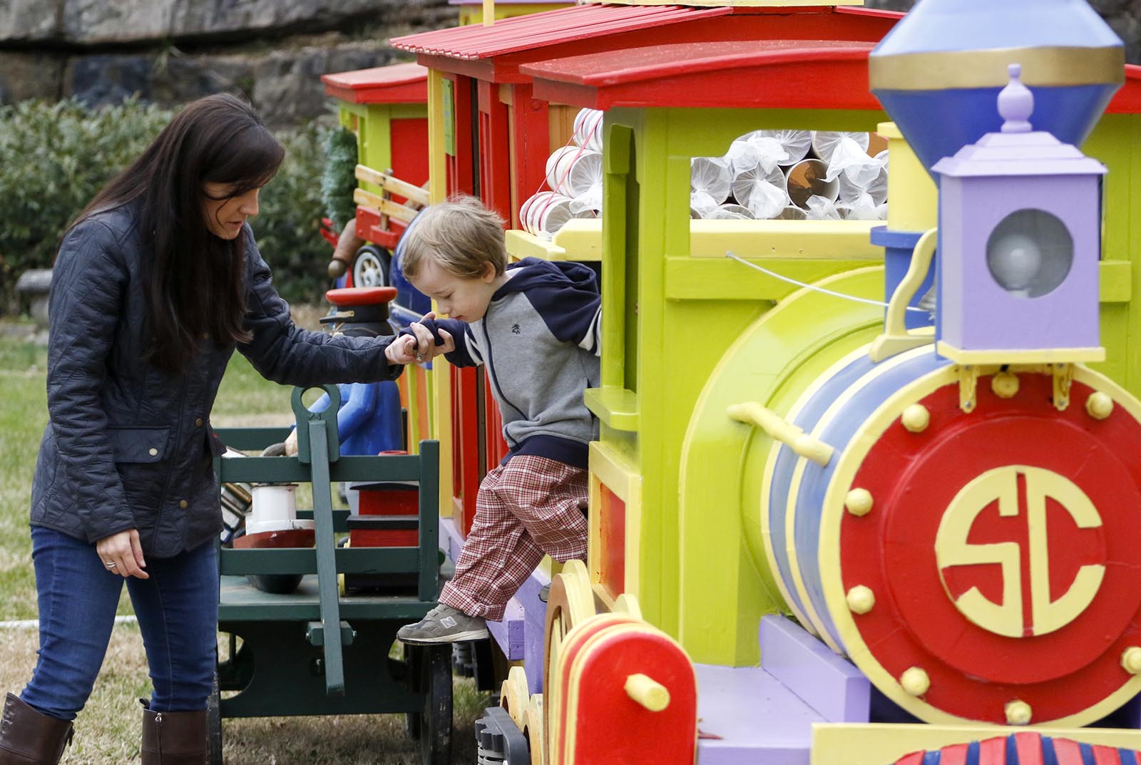 Staff Photo by Dan Henry / The Chattanooga Times Free Press- 12/9/15. Meredith Brown, left, and her three-year-old son Bradford Brown play on a decorated holiday train on display at the top of Signal Mountain on Wednesday, December 9, 2015.