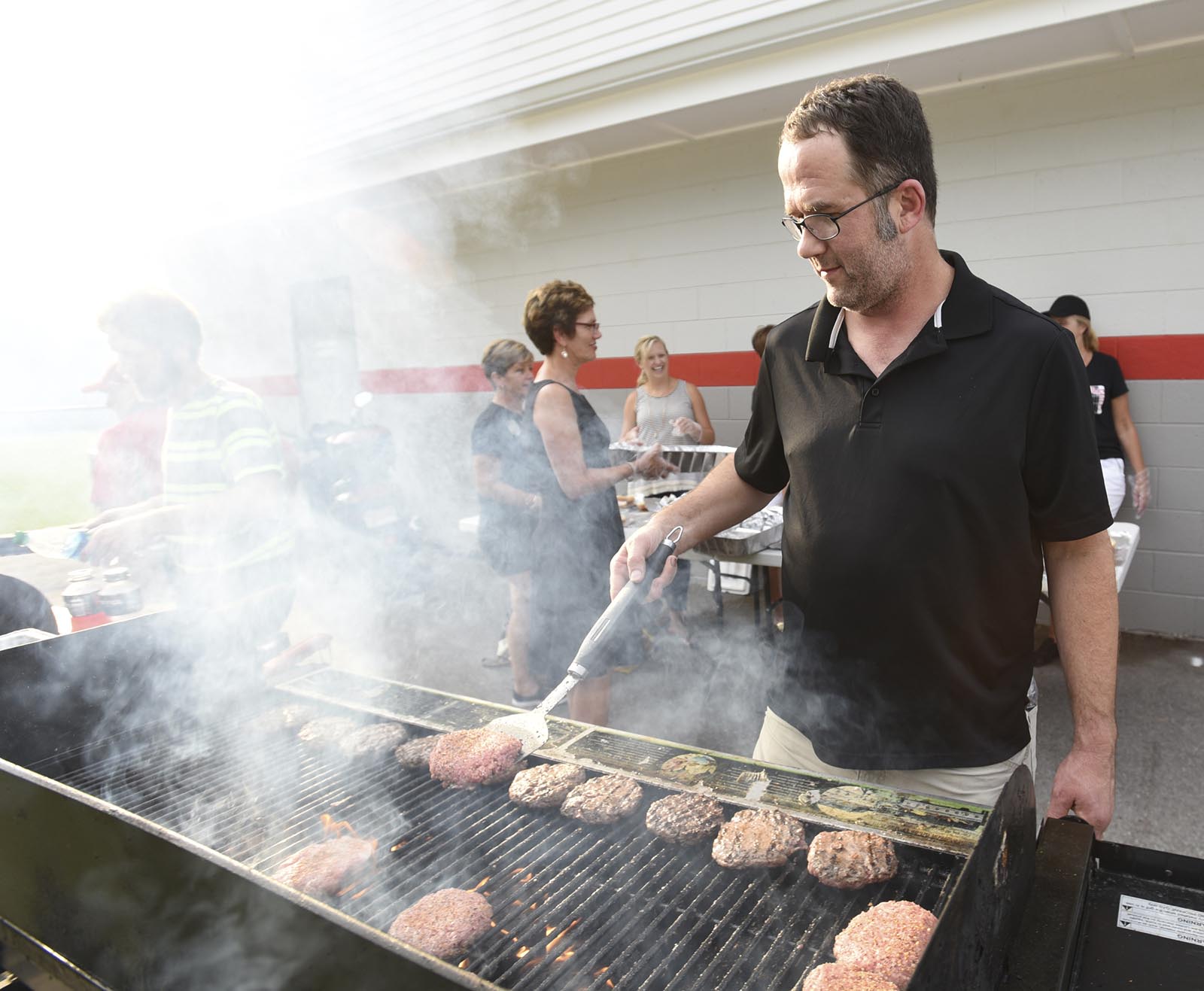 Arden Burns grills burgers before the game between East Hamilton and Signal Mountain Friday, August 21, 2015 at Signal Mountain High School.