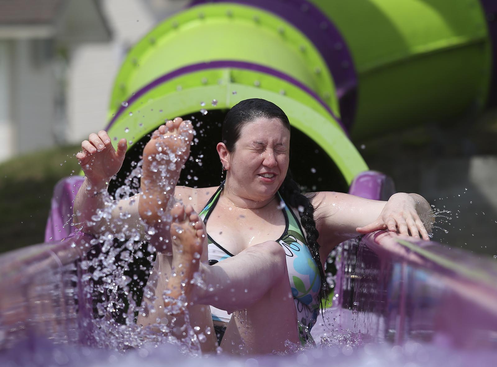 Marissa Moore makes a splash as she makes it to the end of a slide at the water park at Lake Winnepesaukah Amusement Park on Saturday, May 24, 2014. The water park at the amusement park opened for the season Saturday.