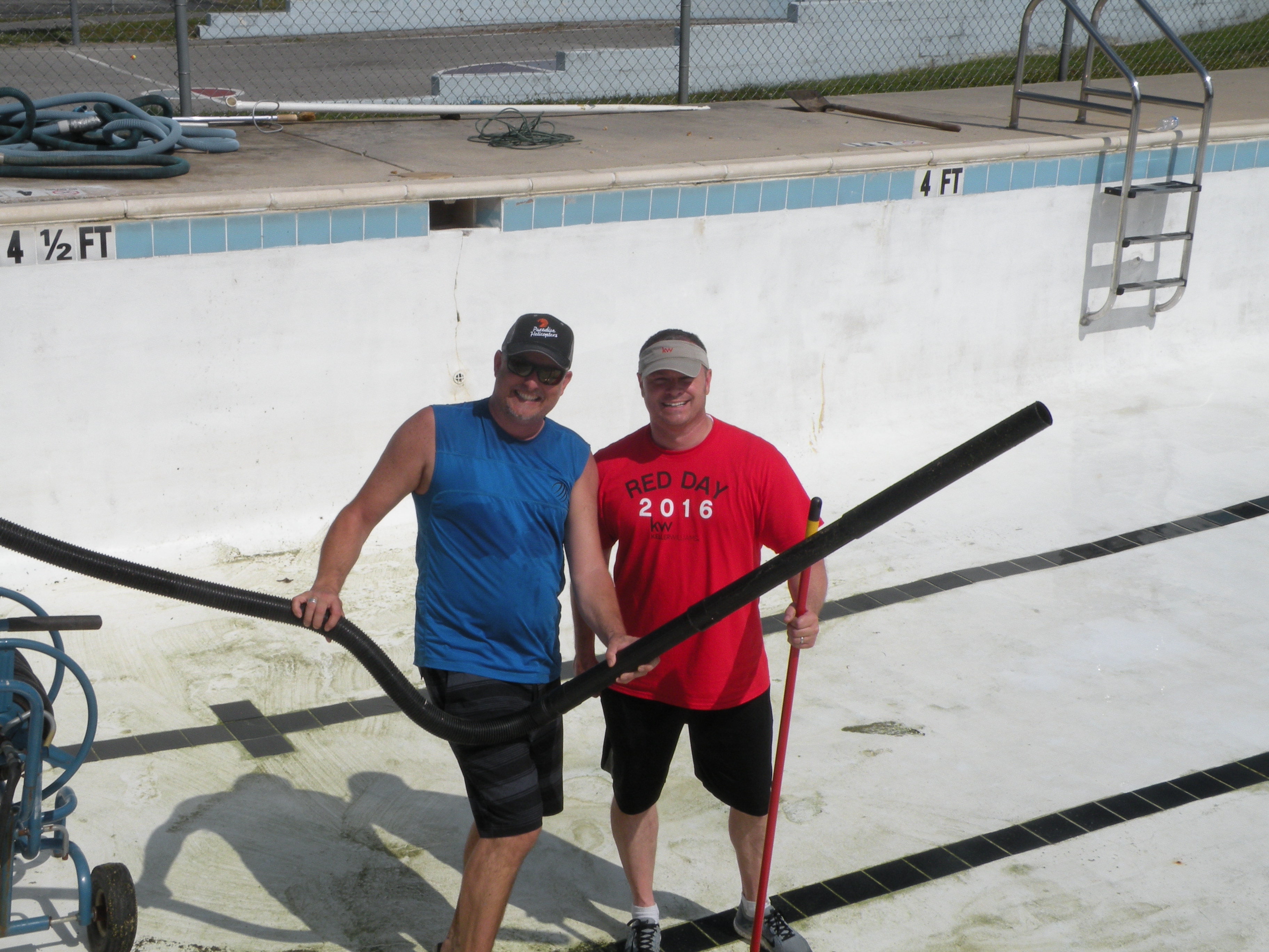 Robert Moss, left, and Joal Henke clean the inside of the pool.