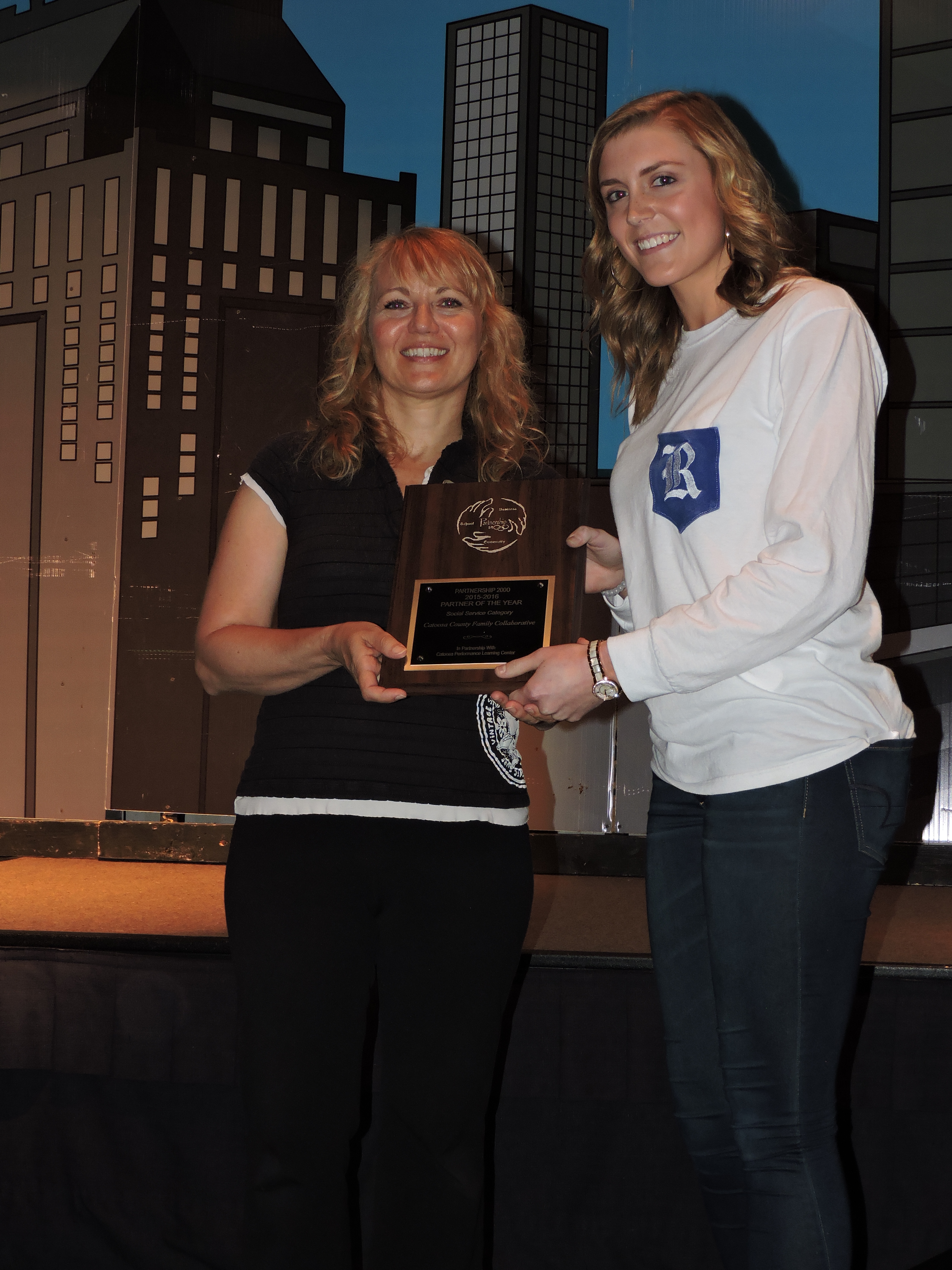 Ringgold High School student Britni Shipp, right, presents the Social Service Partner of the Year award to Colleen Crawford, left, and the Catoosa County Family Collaborative. Crawford worked with the Communities in Schools Program to find resources to help provide rehabilitation opportunities for students dealing with substance abuse issues at the Performance Learning Center. The Family Collaborative helped students work through behavior and drug abuse problems by interacting with members of the "Side Affects" play directed by John Lee.