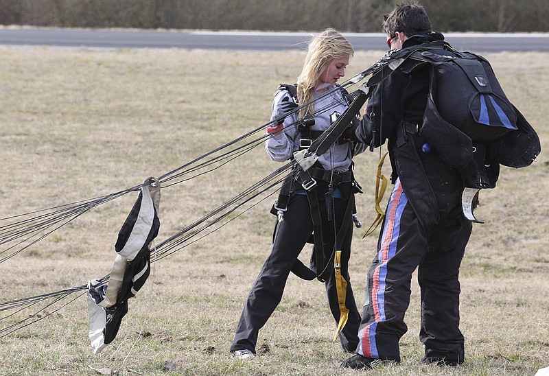 John Nelson, an instructor at Chattanooga Skydiving Company, helps Staffonie Weaver get out of the parachute at the Marion County Airport on Friday, February 28, 2014, in Jasper, Tenn. Weaver and her mother went skydiving to celebrate Weaver's 21st birthday.