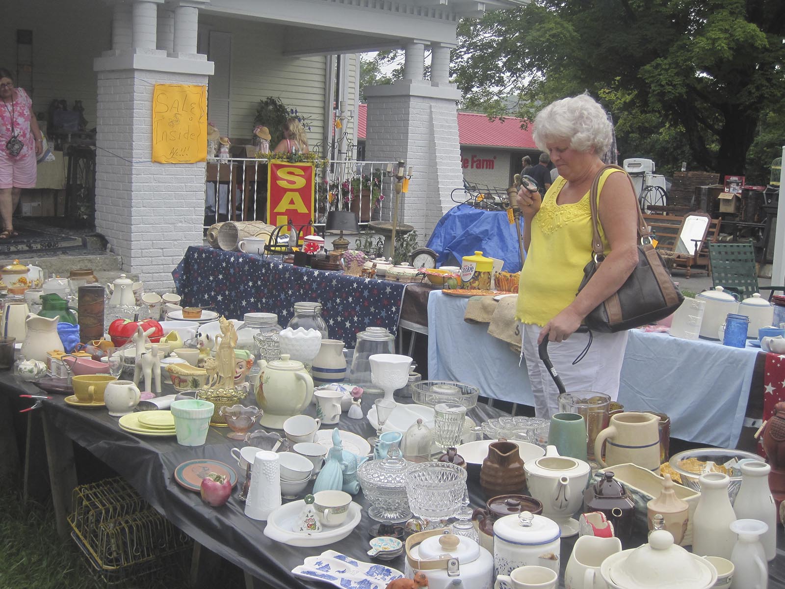 Phyllis Moore of Fort Payne, Ala. looks at breakables through a magnifying glass at the 127 Yard Sale in Dunlap on Friday. 
