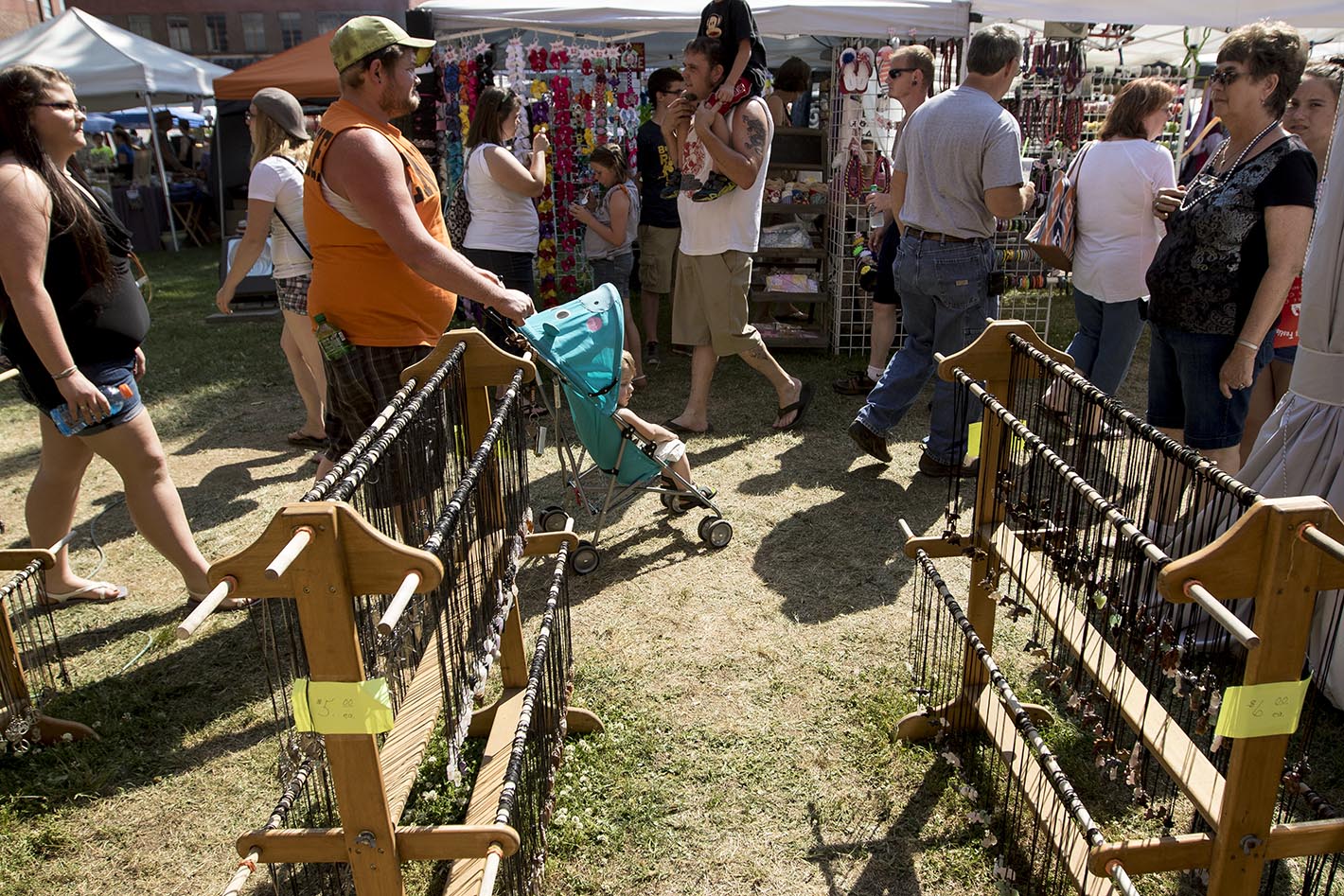 People walk past vendors' tents at the Tennessee Strawberry Festival on Saturday, May 9, 2015, in Dayton, Tenn. The annual festival, held in historic downtown Dayton around the Rhea County Courthouse, brought crowds to browse the wares of craft vendors and food trucks.