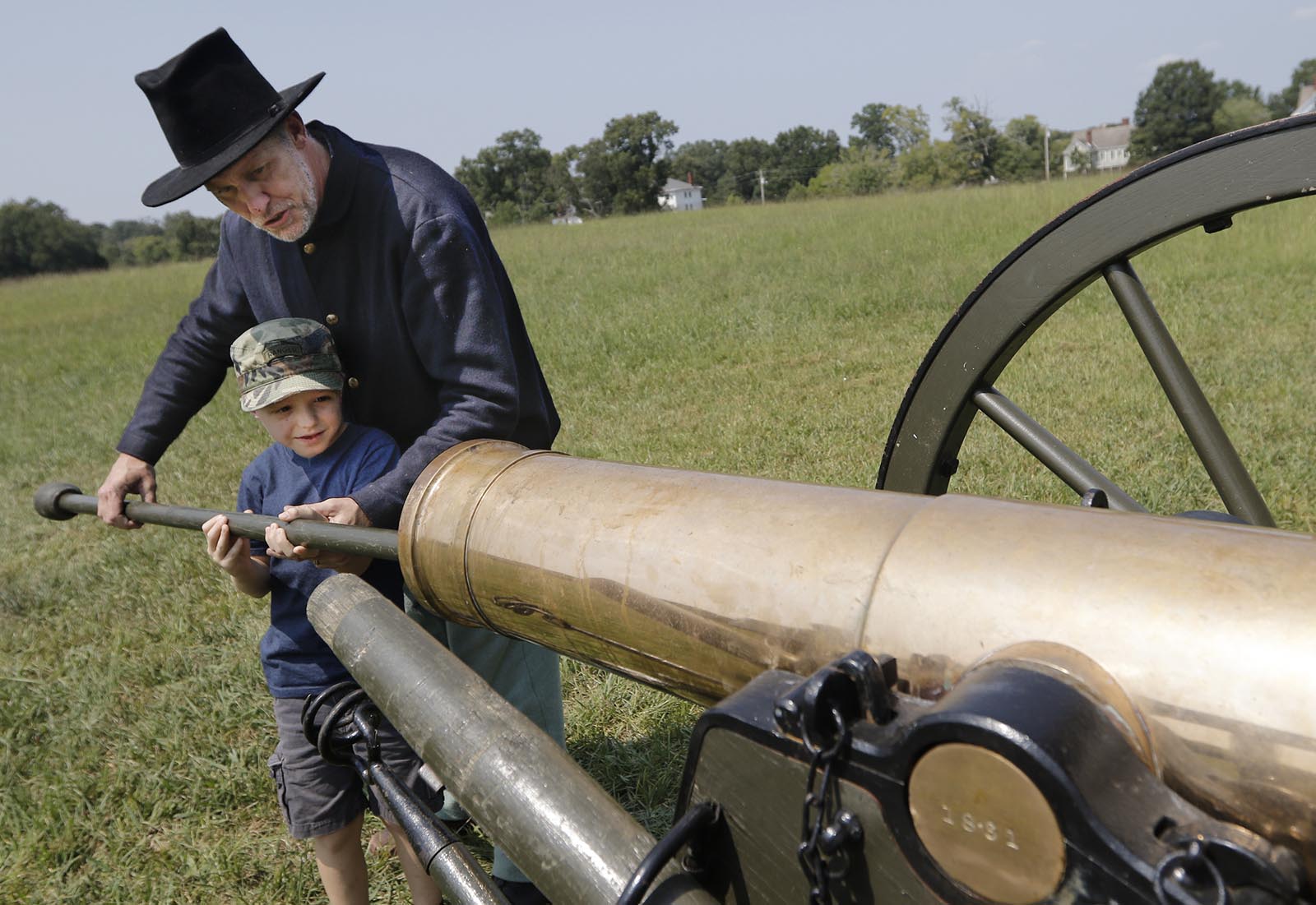 Living historian Jeff Davis shows Troy Cash how a cannon's barrel is cleaned after a living history Civil War artillery demonstration at the Chickamauga National Military Park on Saturday, Sept. 5, 2015, in Fort Oglethorpe, Ga. Multiple demonstrations took place to further educate the public on Civil War history as they visited the park.