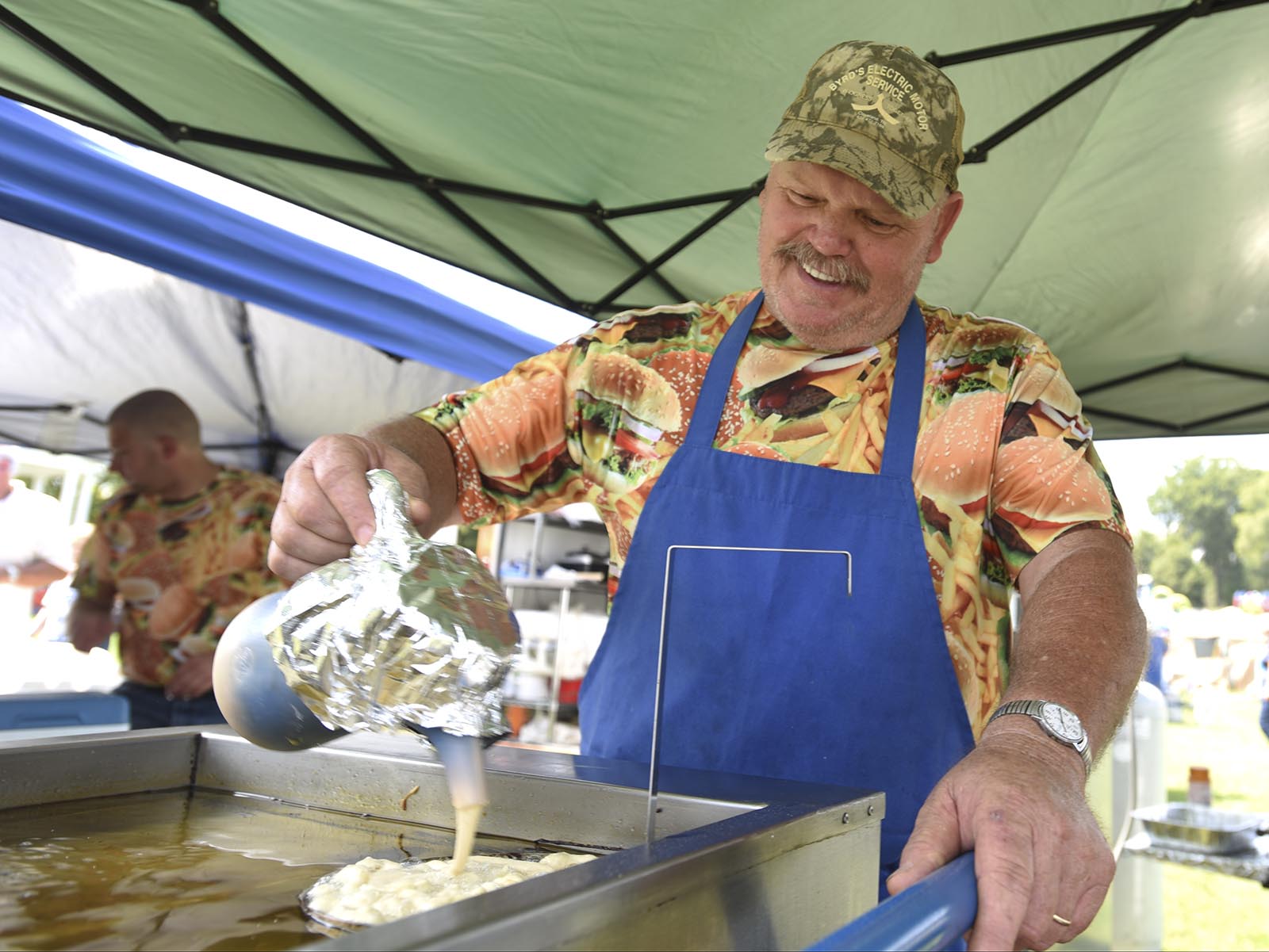 Richard Jackson, owner of Hungry Hollow Concessions, pours a funnel cake into the oil Monday, September 7, 2015 at Labor Day at the Post in Fort Oglethorpe, Ga.